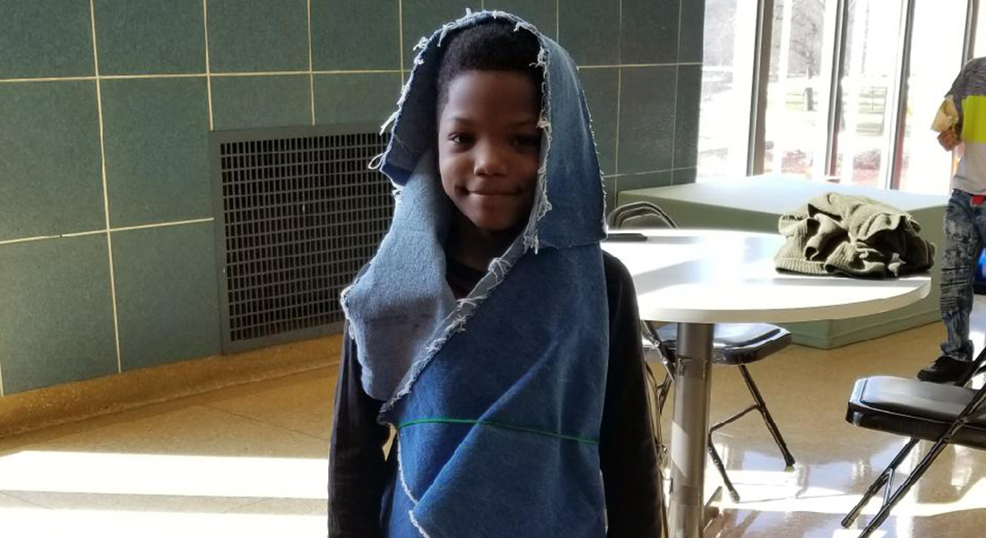 A child wraps himself in fabric.