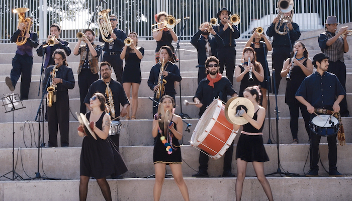 A small marching band performs on an outdoor stairway in a scene from the documentary Santiago, Italia