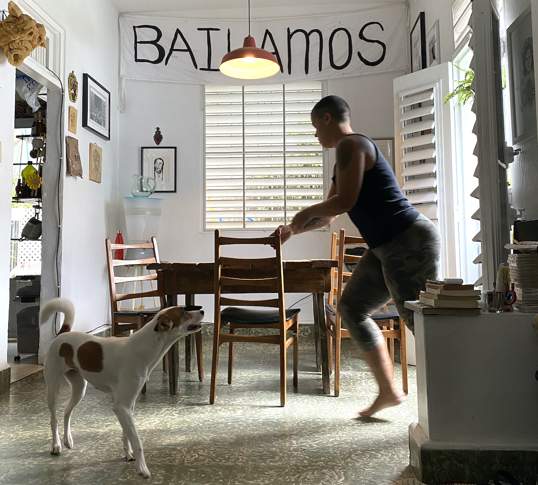 Choreographer Awilda Rodriguez Lora plays with her white, brown-spotted dog in her living and performance space La Rosario in Puerto Rico. 