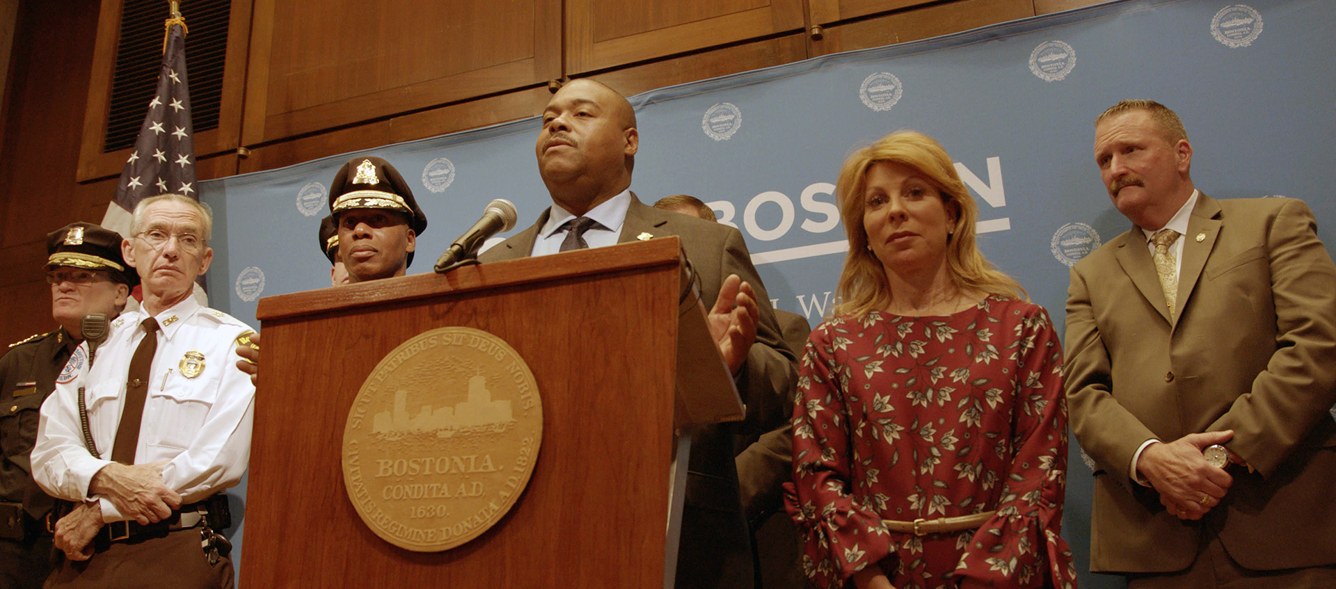 A group of Boston city officials stand at a podium